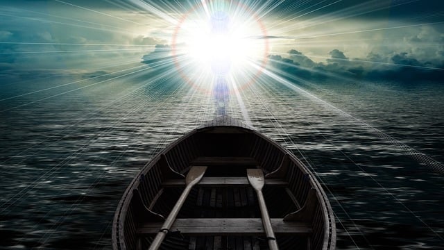 Persona que ha bajado de una barca y se dirige a una fuente de luz celestial.