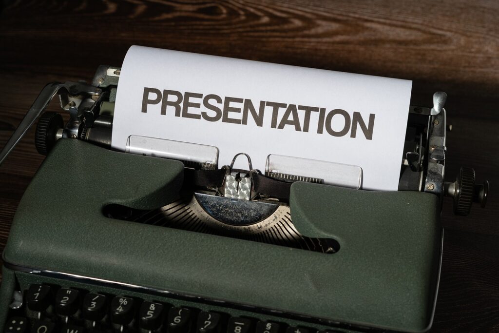 Máquina de escribir antigua con una hoja de papel preparada para escribir, en la que puede leerse "PRESENTATION"